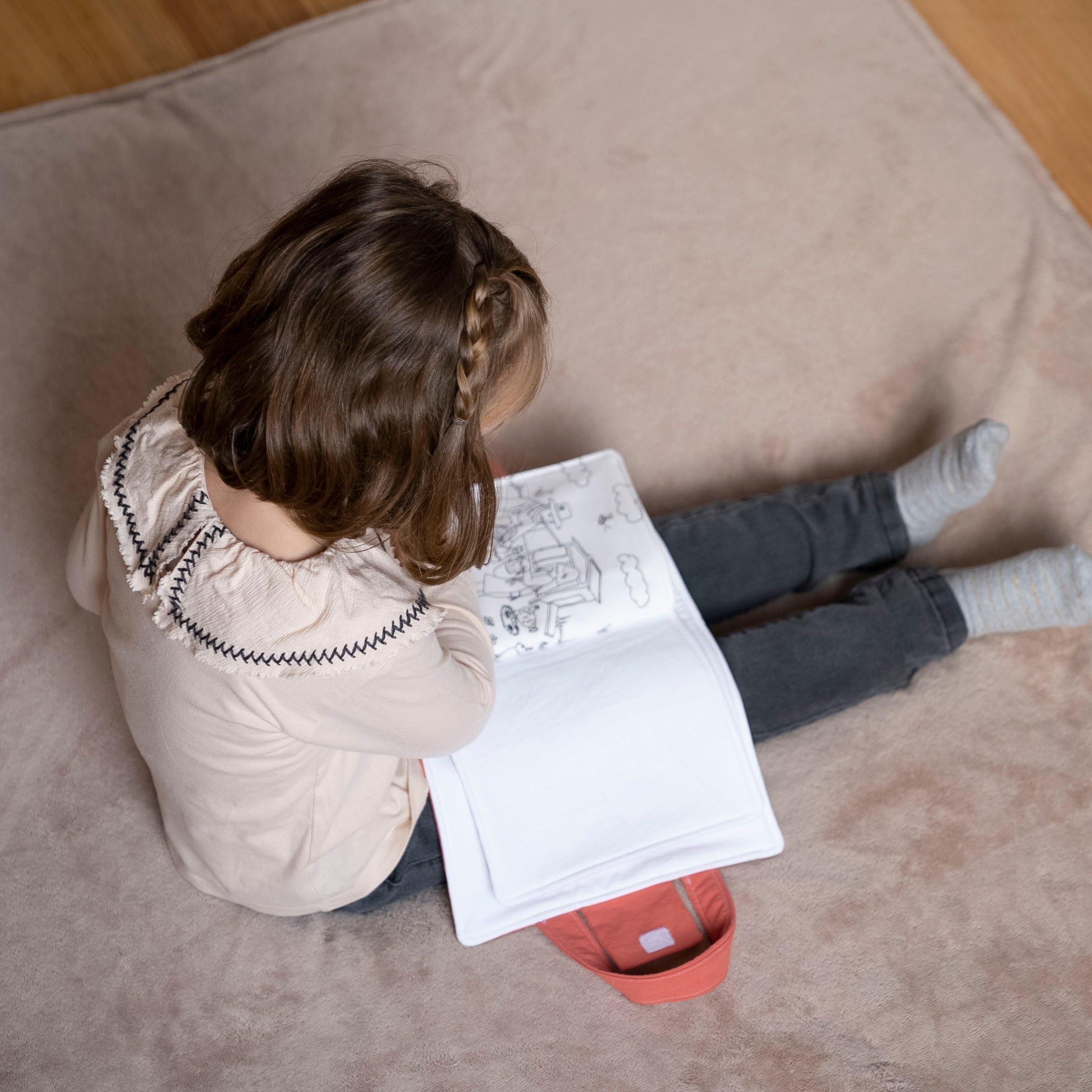 Petite fille qui lit une histoire de la mallette d'activités